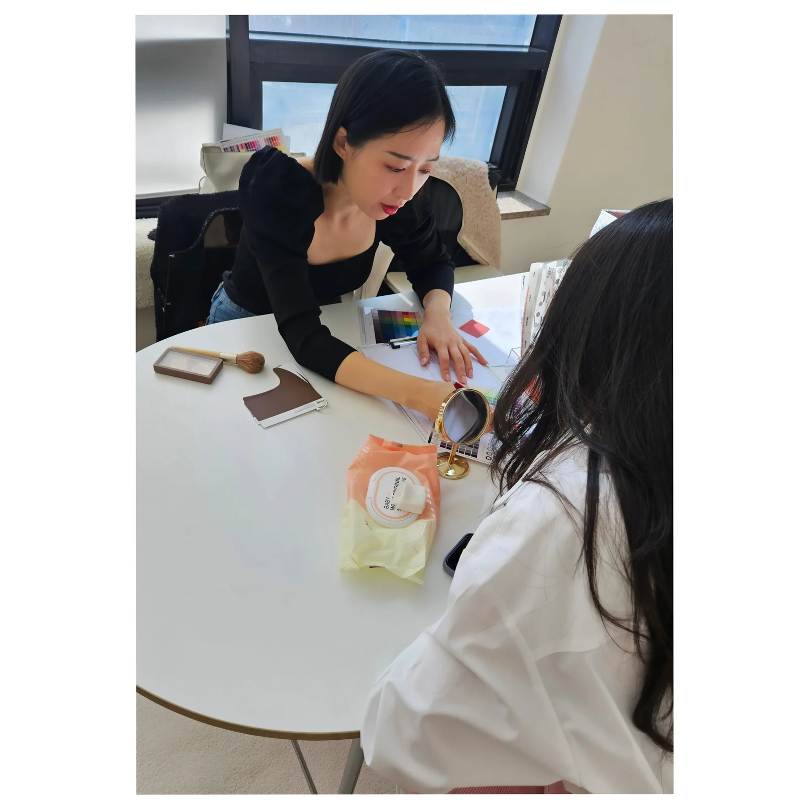 컬러 차트와 상담 자료를 살펴보며 설명하는 유경은 대표